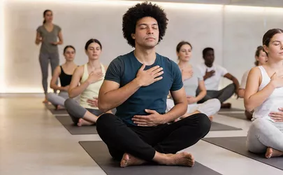 Eine Gruppe sitzt mit geschlossenen Augen auf Matten beim Breathwork