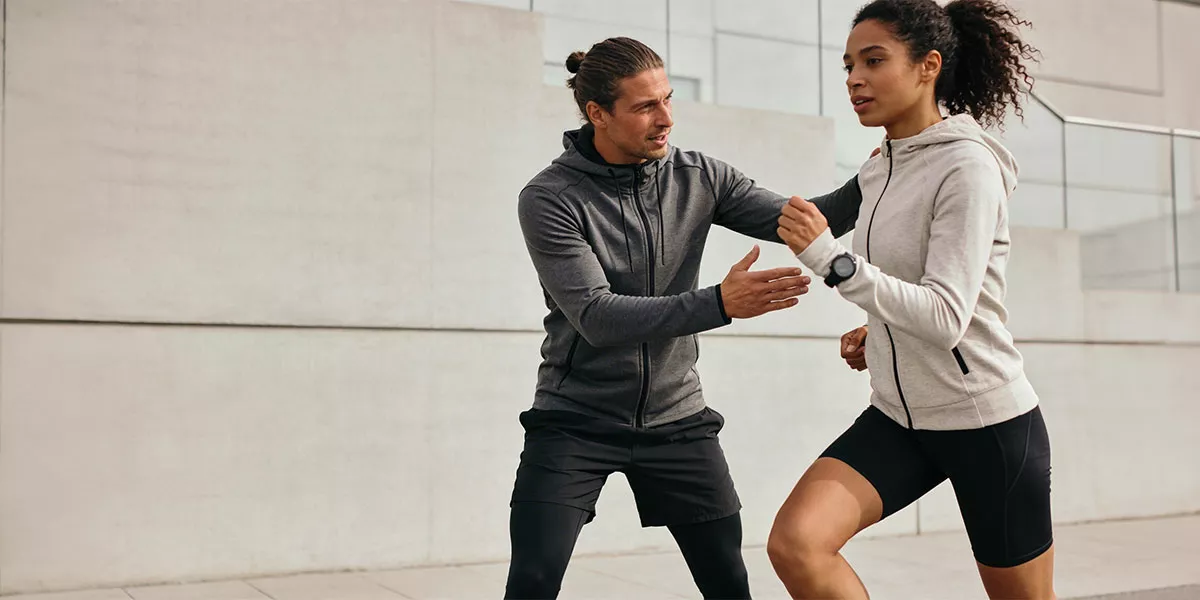 Eine sportliche Frau beim Lauftraining mit ihrem Trainer