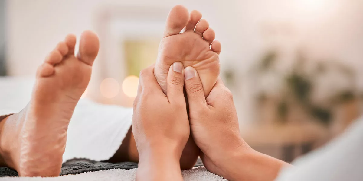 Eine Nahaufnahme von Händen bei einer Fußreflexzonenmassage